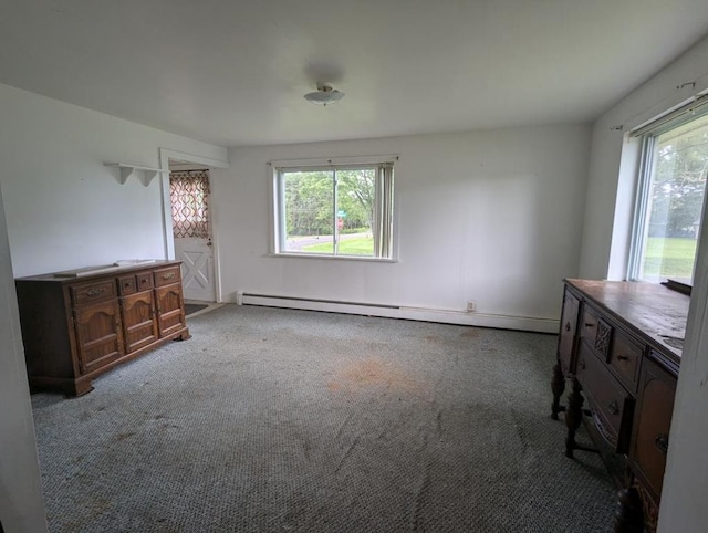 unfurnished bedroom featuring multiple windows, carpet, and baseboard heating