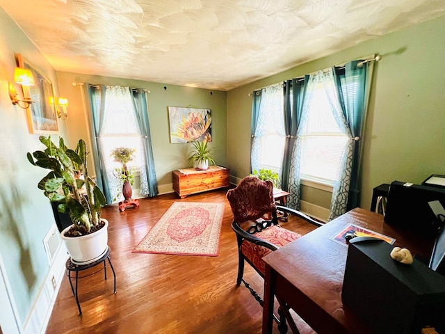 sitting room with hardwood / wood-style flooring and a textured ceiling