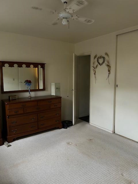 unfurnished bedroom featuring ceiling fan and a closet