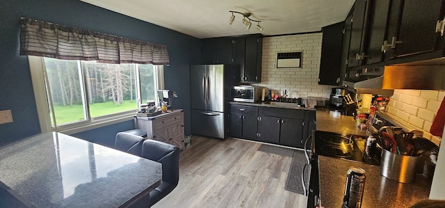 kitchen with appliances with stainless steel finishes and light hardwood / wood-style flooring