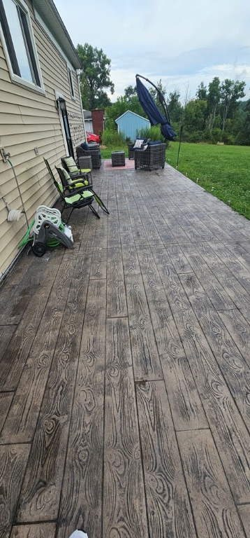 wooden deck featuring a lawn