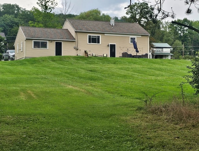 rear view of house featuring a yard