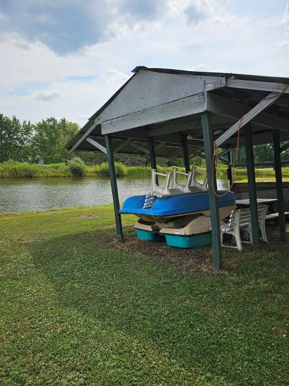 view of dock featuring a water view and a yard