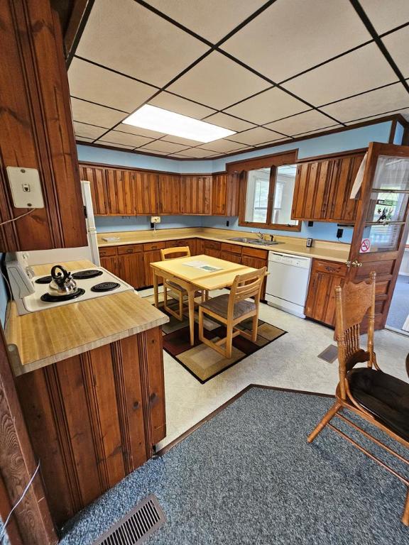 kitchen featuring white appliances, sink, and a drop ceiling