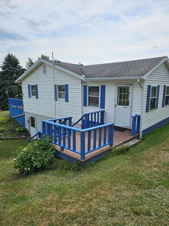 back of house featuring a deck and a lawn