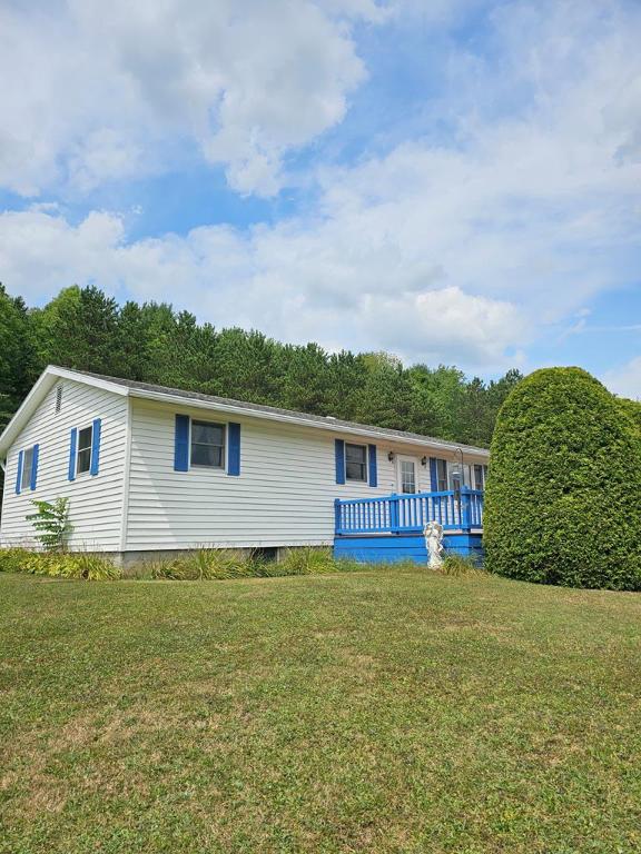 rear view of property with a deck and a lawn