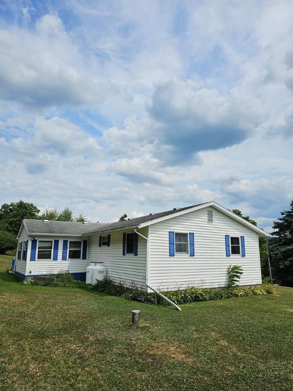 back of house with a lawn