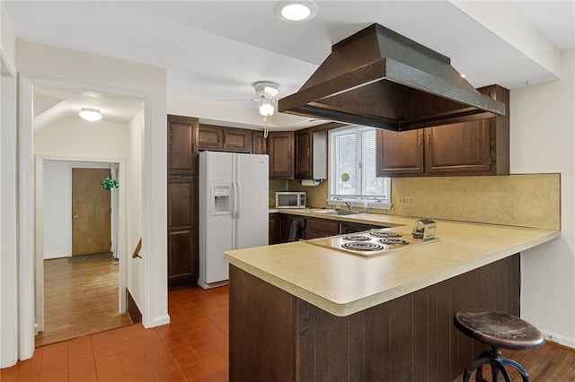 kitchen featuring sink, white appliances, kitchen peninsula, and island exhaust hood