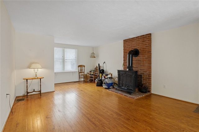 living room featuring wood-type flooring and a wood stove