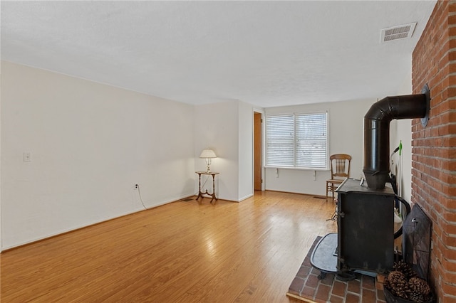 living room with wood-type flooring and a wood stove