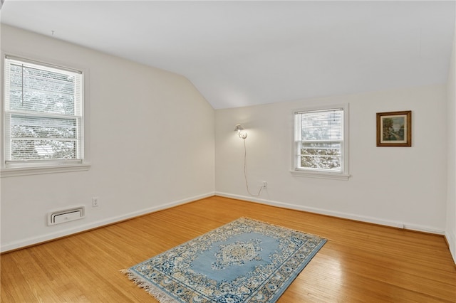 empty room featuring lofted ceiling and wood-type flooring