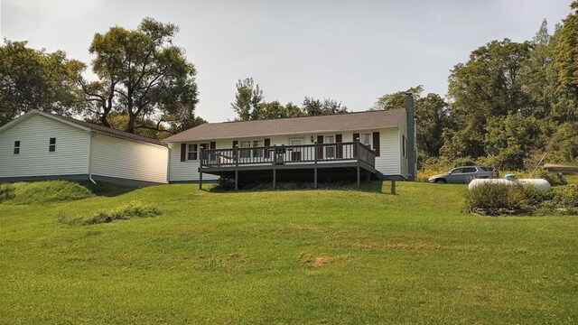 rear view of house featuring a wooden deck and a lawn