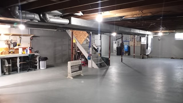 basement featuring heating unit, a workshop area, and water heater