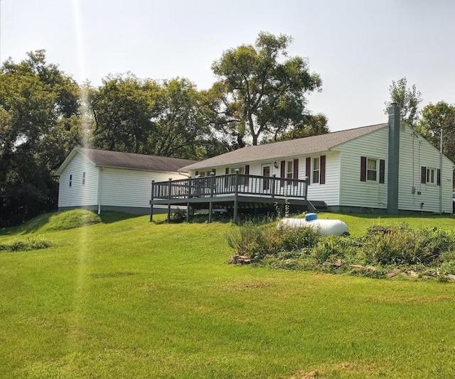 rear view of property featuring a yard and a deck