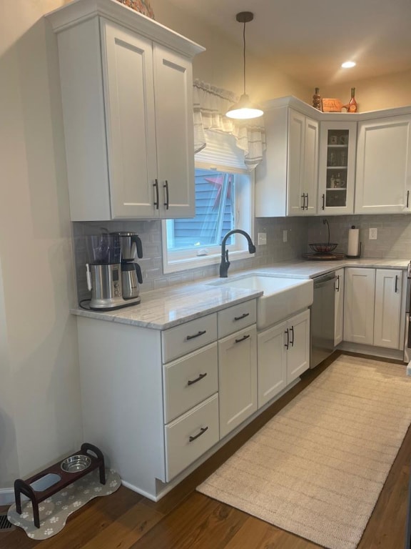 kitchen with white cabinetry, sink, stainless steel dishwasher, and decorative light fixtures