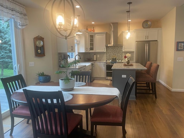 dining space featuring an inviting chandelier, sink, and light hardwood / wood-style flooring