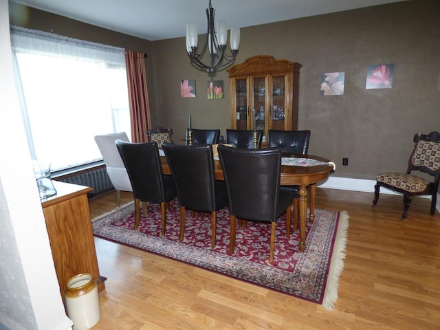 dining space featuring hardwood / wood-style floors and a notable chandelier