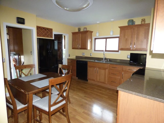 kitchen with sink, light hardwood / wood-style flooring, and black appliances