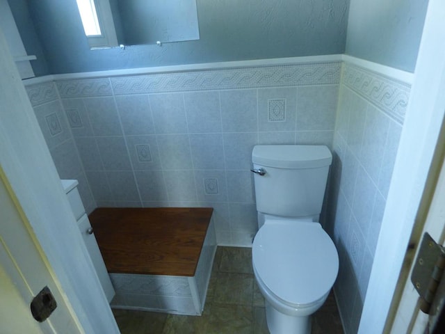 bathroom featuring tile patterned flooring, vanity, tile walls, and toilet