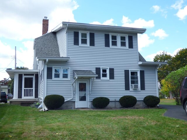 view of front of house with a sunroom and a front lawn