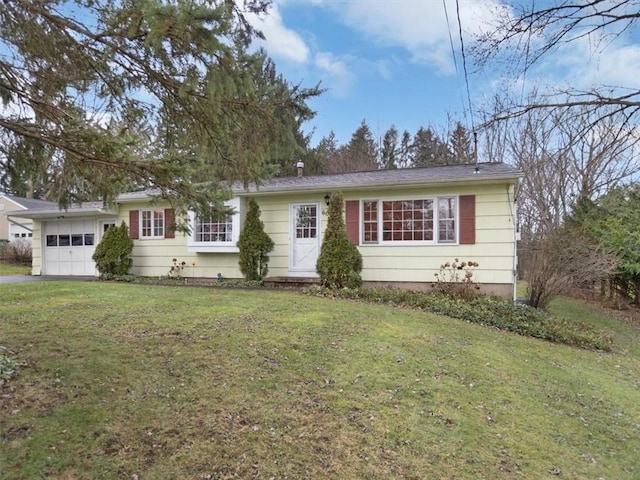 ranch-style home with a garage and a front lawn