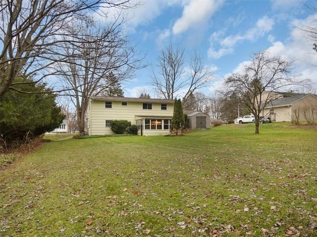 back of house with a storage unit and a lawn