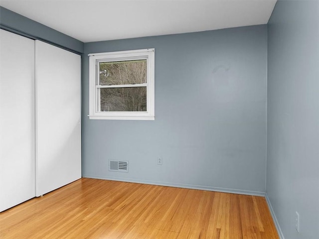 unfurnished bedroom with a closet and light hardwood / wood-style flooring