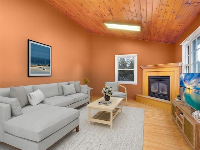 living room with plenty of natural light, light hardwood / wood-style flooring, and wooden ceiling