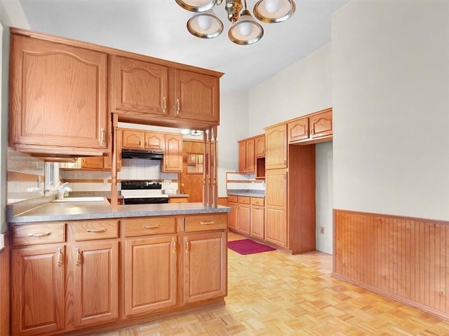 kitchen featuring an inviting chandelier, sink, light parquet floors, and range with electric stovetop