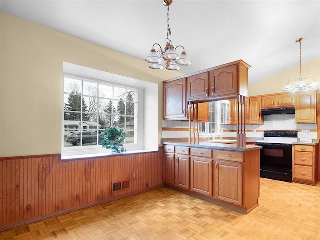 kitchen featuring hanging light fixtures, black electric range, a chandelier, and kitchen peninsula