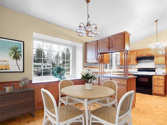 dining room with light parquet floors, vaulted ceiling, and a chandelier