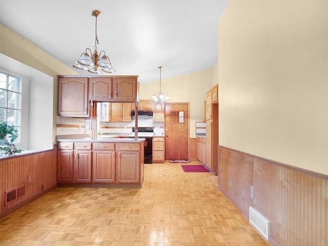 kitchen with range with electric stovetop, wooden walls, decorative light fixtures, light parquet floors, and an inviting chandelier