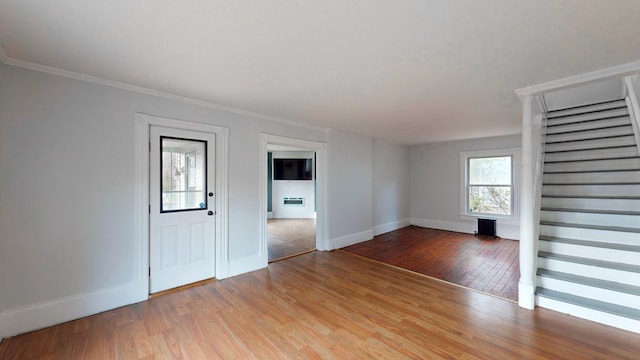 empty room with crown molding, radiator heating unit, and light hardwood / wood-style floors