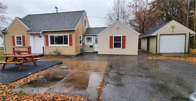 rear view of property featuring a garage and an outdoor structure