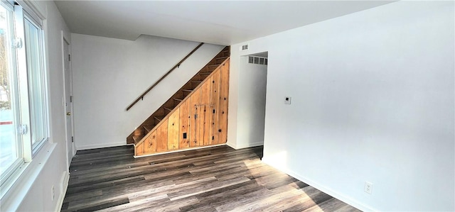 empty room featuring dark wood-type flooring and a wealth of natural light