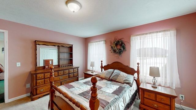 carpeted bedroom featuring multiple windows