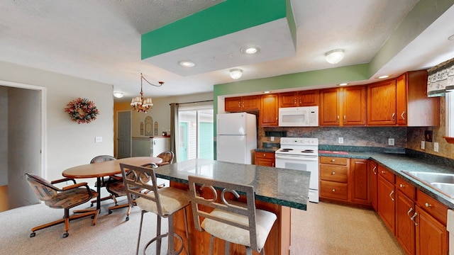 kitchen with white appliances, decorative light fixtures, a center island, and a breakfast bar