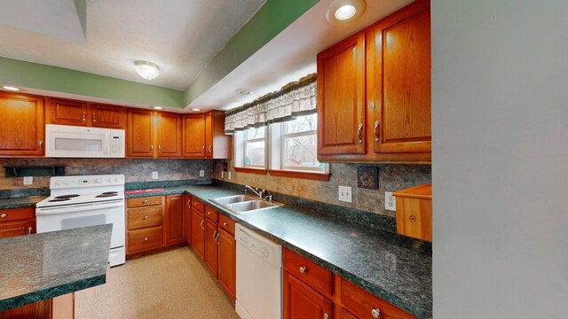 kitchen featuring tasteful backsplash, sink, and white appliances