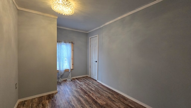 empty room featuring crown molding, dark wood-type flooring, and an inviting chandelier