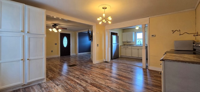 interior space featuring ceiling fan with notable chandelier, sink, and dark wood-type flooring