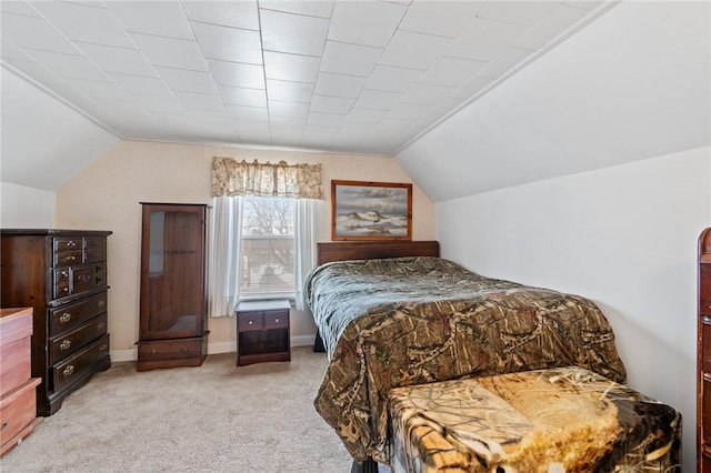 bedroom with lofted ceiling and light colored carpet