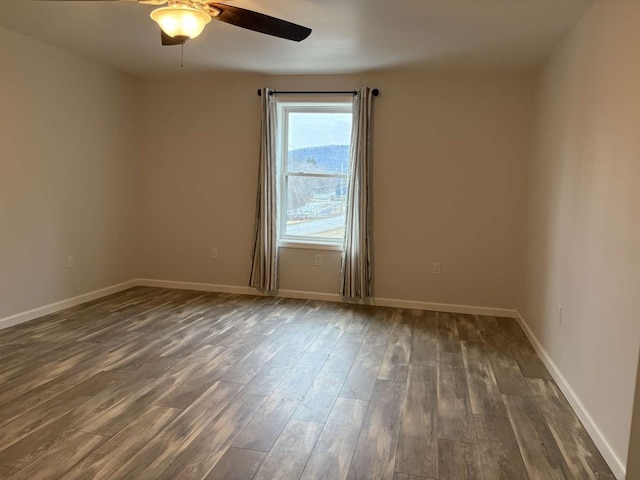 unfurnished room featuring dark wood-type flooring and ceiling fan