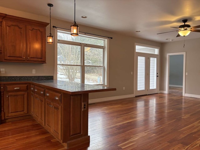 kitchen with ceiling fan, decorative light fixtures, dark hardwood / wood-style floors, and kitchen peninsula