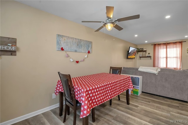 dining area featuring wood-type flooring and ceiling fan