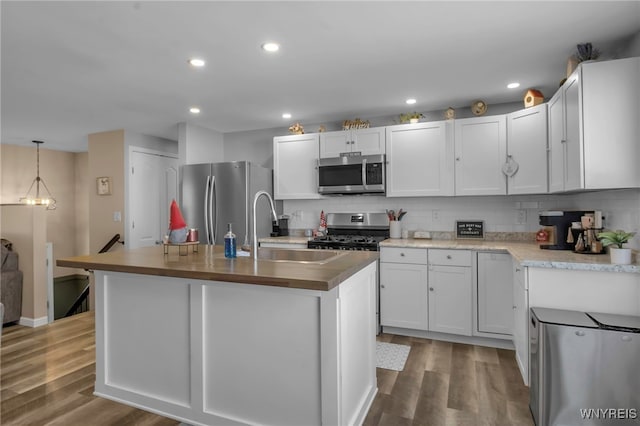 kitchen featuring appliances with stainless steel finishes, sink, a center island with sink, and white cabinets