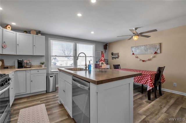 kitchen featuring sink, appliances with stainless steel finishes, a kitchen island with sink, decorative backsplash, and white cabinets