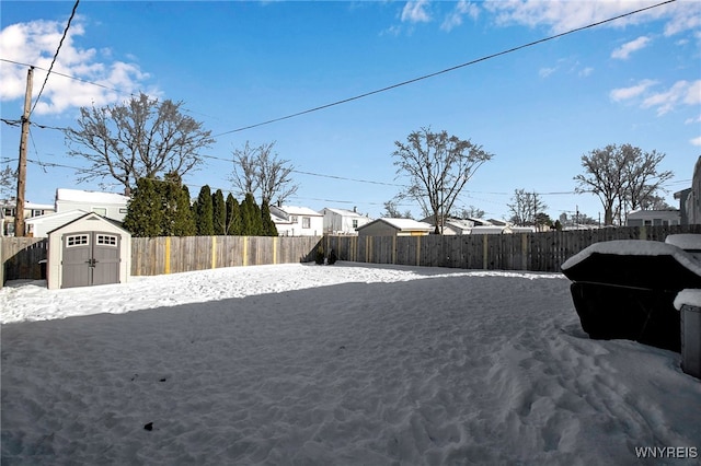 yard layered in snow featuring a storage shed