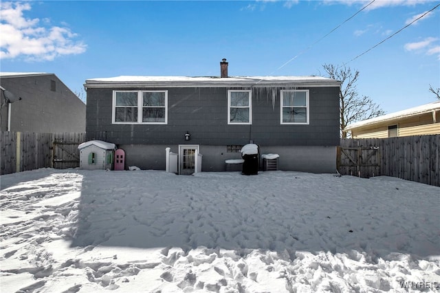 snow covered house featuring cooling unit