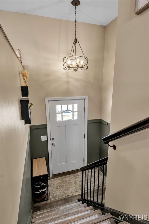 foyer with wood-type flooring and a notable chandelier