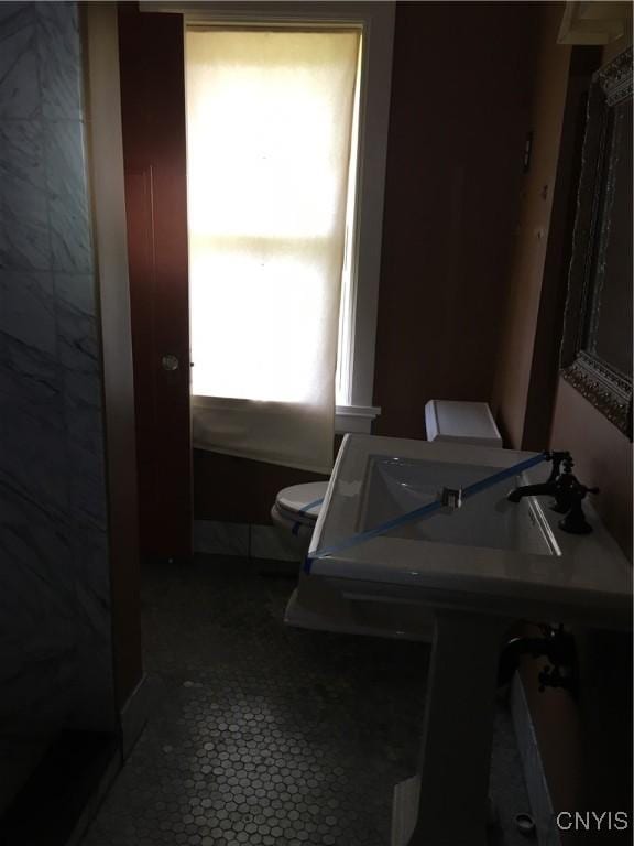 bathroom featuring a wealth of natural light and toilet